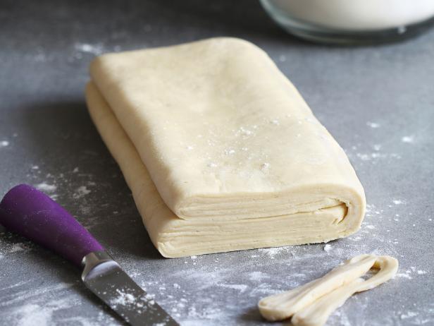 Homemade puff pastry dough on a floured surface