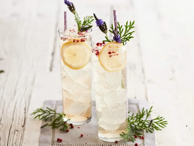 FNK LAVENDERPINK PEPPERCORN VODKA SODAS Food Network Kitchen Food Network Sugar, Dried Lavender, Pink Peppercorns, Vanilla Bean, Vodka, Club Soda, Lavender, Lemons