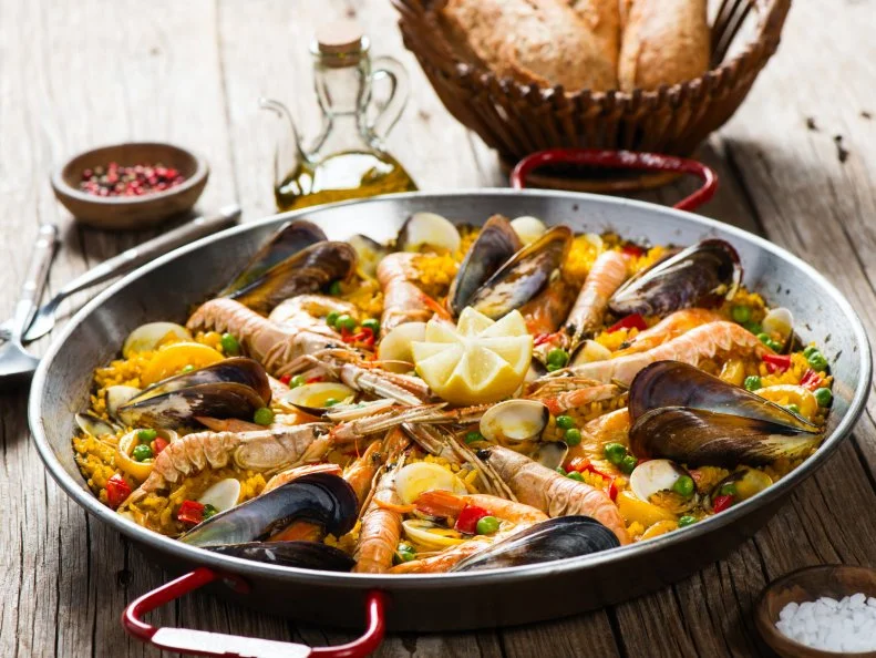 Closeup of paella with seafood on a wooden table, selective focus.