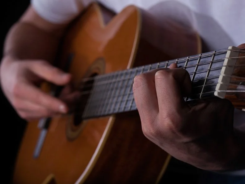 Close-up of man playing on guitar, horizontal