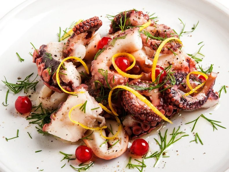 Close-up of Octopus Salad in plate on white background.