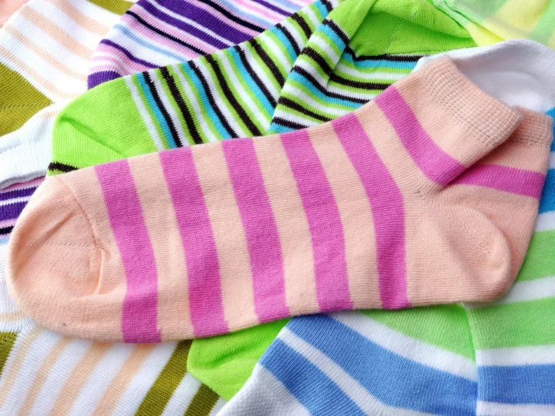 Stack Of Many Pairs of Colorful Striped Socks isolated On White Background