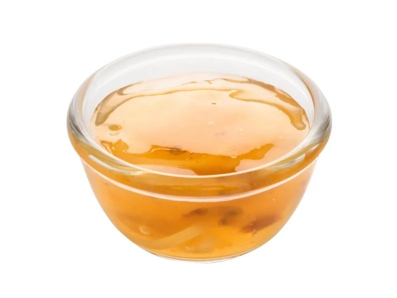 close up of a bowl of chinese plum sauce isolated
