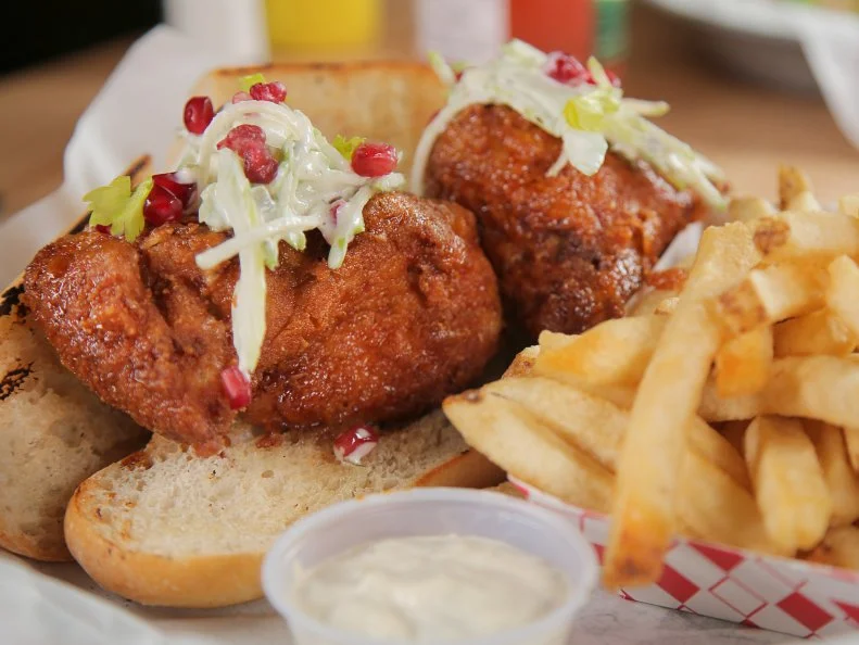 WS of fried chicken sandwich and beef tallow fries at Clove and Hoof in Oakland, CA as seen on Food Network's Diners, Drive-Ins and Dives, season 24.