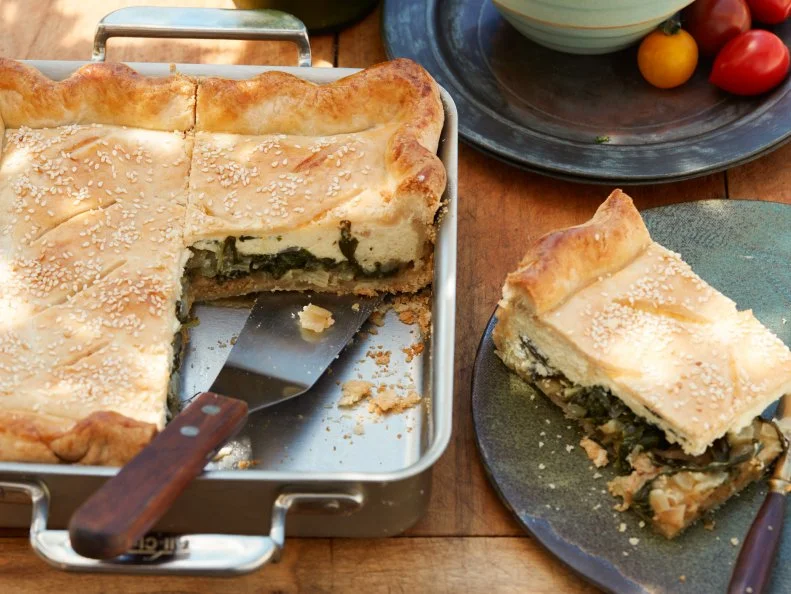 FNK SWISS CHARD AND RICOTTA SLAB PIE, Food Network Kitchen, Food Network, Allpurpose Flour, Sugar, Unsalted Butter, White Vinegar, Olive Oil, Yellow Onions, Swiss Chard, Garlic, Ricotta, Parmesan, Eggs, Breadcrumbs, Sesame Seeds