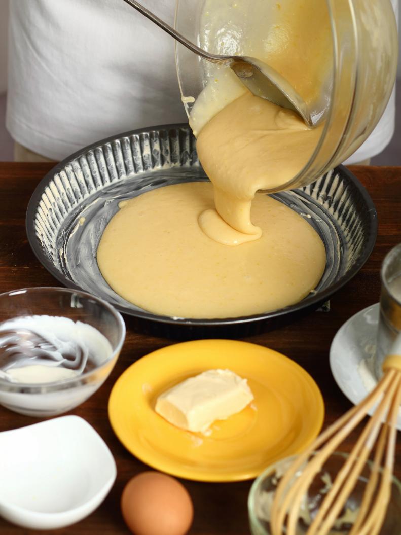Making Sour Cream Lemon Cake. Pouring cake batter into baking tin.