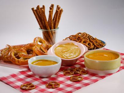Pretzel dips, from left, beer mustard, Sriracha mustard and cheesy mustard are displayed during an episode about the best snacks ever, as seen on Food Network's The Kitchen Sink, Season 1.