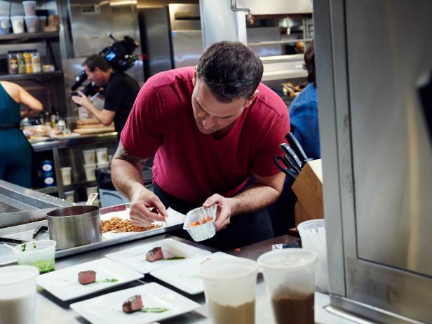 Finalist Aaron Crumbaugh preparing his dish, Coffee Rubbed Flat Iron Steak with Pickled Peppers and Red Onions, Chimichurri, and Fried Shallots, for the Star Challenge, as seen on Food Network Star, Season 12.