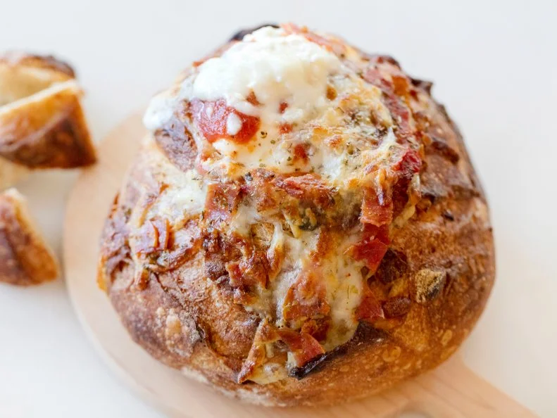 Bread bowl filled with pizza sauce cheese and topped with pepperoni