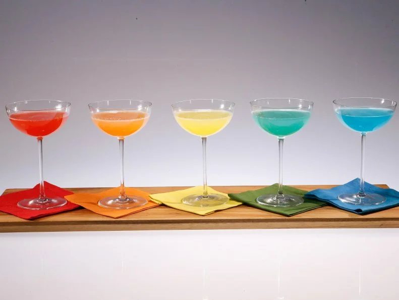 Rainbow mimosas are displayed during an episode about rainbow foods to brighten your day, as seen on Food Network's The Kitchen Sink, Season 1.