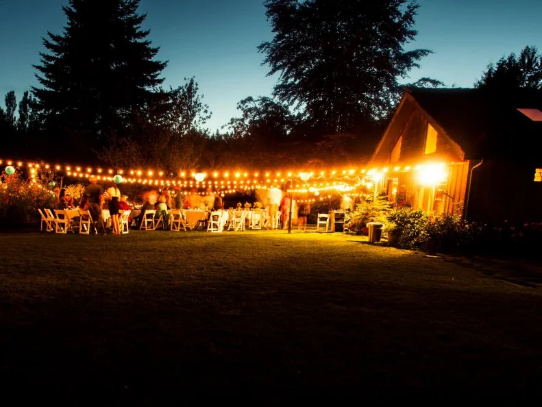 Long exposure of an outdoor wedding ceremony at twilight and guests having a fun party. Motion blur makes any people unrecognizable.
