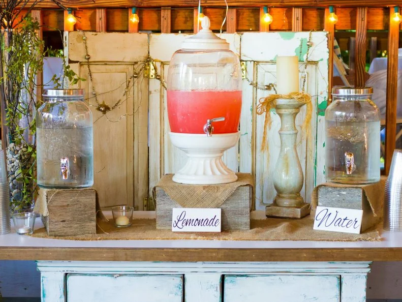 Pink lemonade stand at a wedding reception offers drinks for the guests.