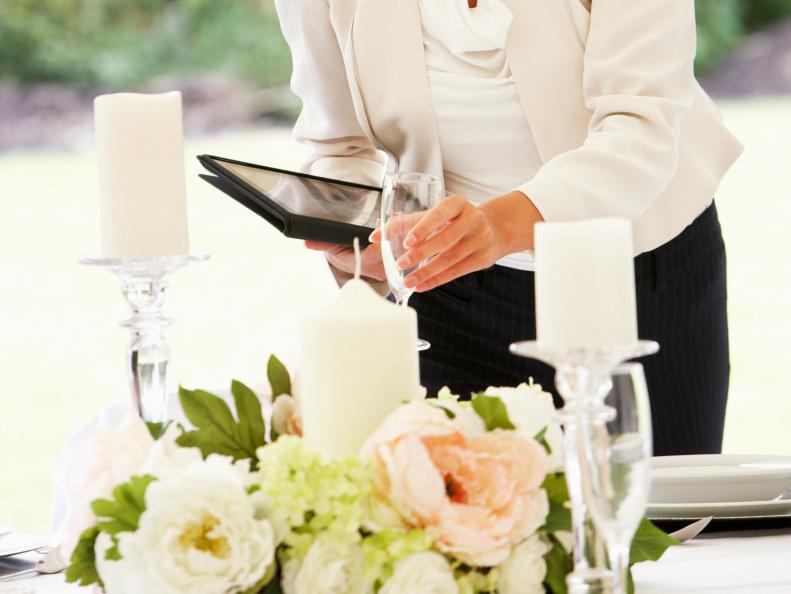 Female Wedding Planner Checking Table Decorations In Marquee