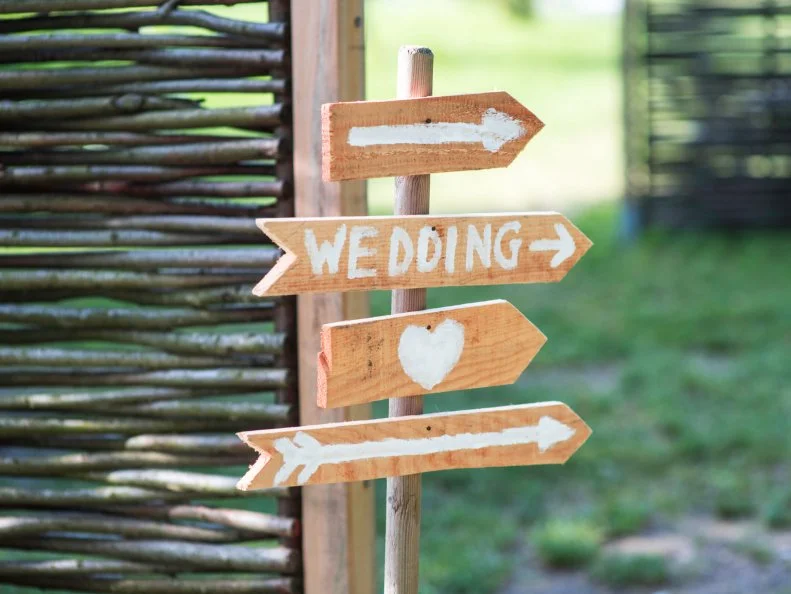 Signs outdoors with a heart, arrows and the word wedding. Would suit a catalogue of wedding gifts, the cover of a wedding album, a wedding photography site...