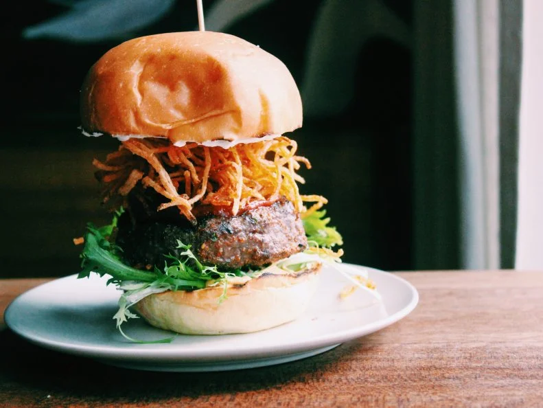 Inspired by the Japanese izakaya concept of a small bar serving excellent food, this Portland spot offers a daily menu featuring local and organic ingredients. The sushi is a main draw, but the Asian-perfumed Yakuza Burger is a serious crowd-pleaser. Fortunately, it’s offered on the regular. Local grass-fed Angus beef is dry-aged for 21 days and pressed into a juicy patty. Once formed, the patty is seasoned with Japanese togarashi spices and fired over direct heat. It’s then topped with creamy chevre, spice- and truffle-infused shoestring potatoes, ketchup, and spicy mayo laced with Sriracha for an added kick.