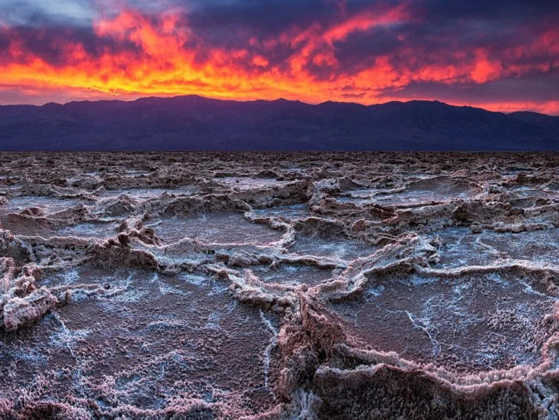 Breaking clouds and a sunset combine to create drama in the skies over Badwater in California's Death Valley National Park.  At 282 feet below sea level, Badwater is the lowest point in North America.