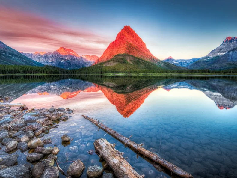 Stunning reflections on Swiftcurrent Lake in northern Montana at sunrise