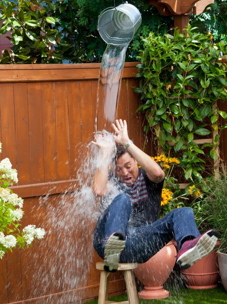 Host Sunny Anderson soaks host Jeff Mauro during the Kickin' Bucket Cocktail Demo, as seen on Food Network's The Kitchen Season 10.