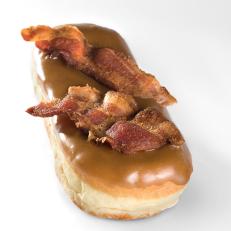If you see someone carrying a pink box onto an airplane at PDX, chances are good that yeast doughnuts from Voodoo Doughnut are inside. Topped with maple frosting and an entire piece of bacon broken in half, the Bacon Maple Bar is one of the simpler doughnuts on Voodoo’s cheeky menu, which also includes the Marshall Mathers (made with M&M’s — get it?) and a chocolate cake version topped with a vanilla-icing pentagram. 