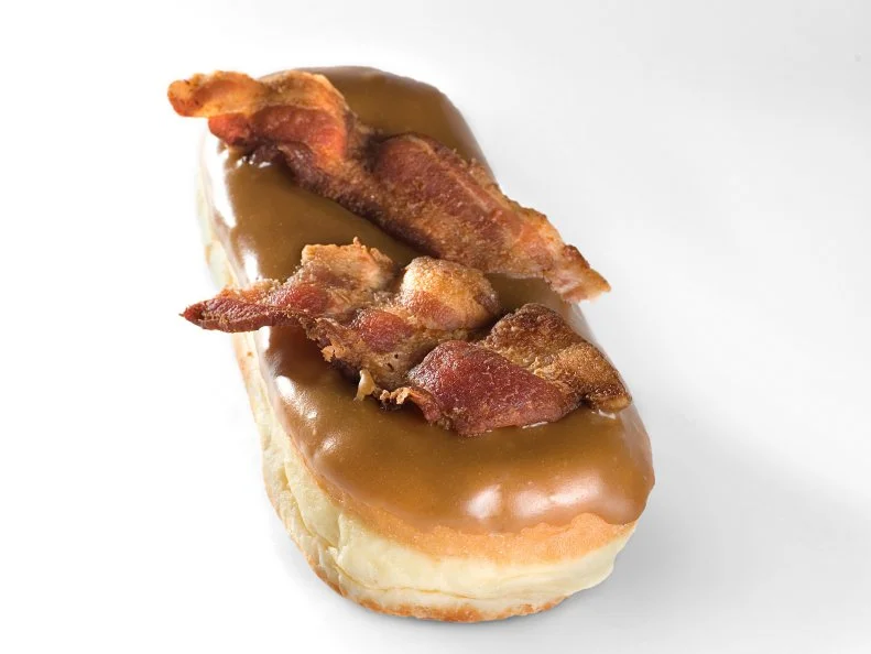 If you see someone carrying a pink box onto an airplane at PDX, chances are good that yeast doughnuts from Voodoo Doughnut are inside. Topped with maple frosting and an entire piece of bacon broken in half, the Bacon Maple Bar is one of the simpler doughnuts on Voodoo’s cheeky menu, which also includes the Marshall Mathers (made with M&M’s — get it?) and a chocolate cake version topped with a vanilla-icing pentagram. 