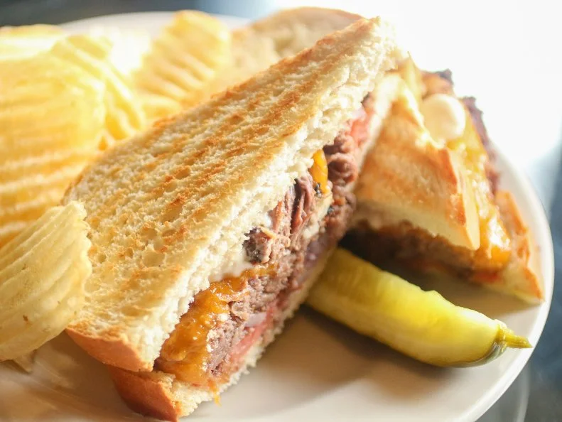 Slow-cooked pot roast is a good ol’ American classic that gets an even more Americana upgrade in the form of a pot roast melt sandwich. You can find it on Denny’s lunch and dinner menu, but one of the homiest restaurant versions is served at Cathedral Cafe & Bookstore near Fayetteville, West Virginia’s New River Gorge. The former church-turned-restaurant-and-bookshop combines shredded chuck roast, cheddar cheese, tomato, red onion and spicy horseradish mayo on grilled sourdough that’s so good you’ll almost want to pack up and move to the Mountain State. 
