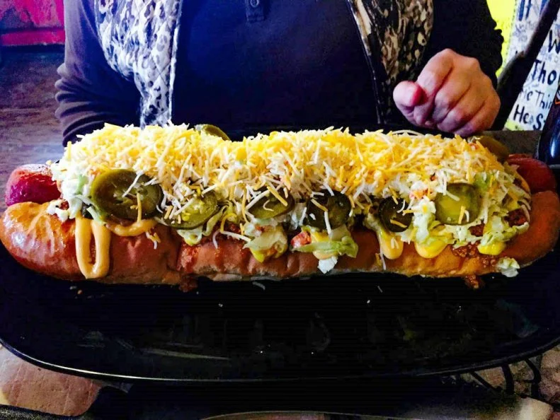 Think the lowly hot dog is nothing to get excited about? Just says the words “West Virginia Dog” around these parts and watch the drooling commence. In a world of gourmet hot dogs topped with everything from kimchi to truffles, there’s something to be said for the simple pleasures of a good old-fashioned dog. In West Virginia, that means toppings of chili, mustard, onions and slaw – preferably on a dog nestled in a split-top (and sometimes butter-toasted) English bun. Although folks flock to Hillbilly Hotdogs near Huntington for dozens of crazy combinations (including the whopping 15-inch Homewrecker), this rustic roadside joint serves up a classic West Virginia Dog like no other.