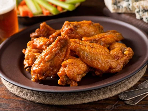 We wouldnâ  t want you to NOT have the wings at Buffalo Wild Wings. And lucky for you, they may just be the healthiest thing on the menu! Just a few tips for ordering: Go for traditional wings, rather than boneless (theyâ  re more whole foods-based) and get the snack size. For the least added sugar and sodium go for the buffalo, chipotle, desert heat, lemon pepper and salt & vinegar flavors. The snack-size buffalo traditional wings deliver 340 calories, 6 grams of saturated fat, 530 mg of sodium and 41 grams of protein. Make sure you eat the carrot and celery sticks, too, for a small dose of vegetables. The fiesta pork tacos are another good choice providing 450 calories, 30 grams of protein, 10 grams of fat, 1100 mg of sodium and 3 grams of fiber.