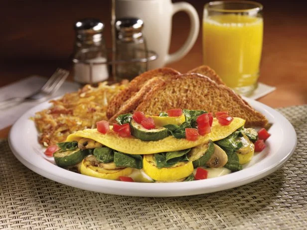 Dennyâ  s Fit FareÂ® menu is the place to look for some healthier options. If youâ  re hungry for breakfast, try the Fit FareÂ® Loaded Veggie Omelette, an egg white omelette thatâ  s stuffed with zucchini, mushrooms, tomatoes and onions and served with fruit and an English muffin. For dinner, try the Fit FareÂ® Tilapia Ranchero topped with pico de gallo and avocado and served with mashed potatoes and broccoli. Both options give you plenty of protein, veggies and fiber.