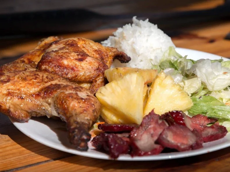 Mike Fuse remembers the smell of kalua pork cooking in the ground leading up to neighborhood luaus in his hometown of Haleiwa. He loved the aromas of meat and smoke wafting through the air. So he decided to continue the tradition, opening Mikeâ  s Huli Huli Chicken in 2010. At his open-air, roadside place, Fuse cooks its namesake dish over wood, slow-roasting his birds with just Hawaiian sea salt on a rotisserie. When itâ  s almost done he transfers the rotisserie to a pit heated by the scorching hot kiawe wood, which Fuse says could be considered Hawaiian mesquite. The result is extra-crisp skin encasing juicy and smoky meat. Word to the side: Come hungry. Fuse also serves incredible Chinese-style char siu pork, as well as kalua pork that probably tastes even better than the dish of his childhood memories.