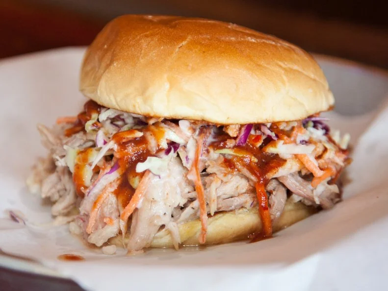 Go whole hog â   literally! â   at this renowned barbecue joint that specializes in West Tennesseeâ  s legendary whole-hog barbecue tradition. Nationally celebrated pitmaster Pat Martin starts cooking his 200-pound pigs a full day before they come out of the custom-built brick pits set in the dining room of each one of his half-dozen locations. Hogs are flavored with aromas of hickory, Martinâ  s own dry-rub blend and his rendition of the traditional West Tennessee sauce, a slightly sweet blend of vinegar and tomato. Barbecue trays and sandwiches are on the menu (including housemade bologna), but the Redneck Tacos are a favorite. Cornbread hoe cakes are topped with slaw and sauce with a choice of barbecue pork, beef brisket, sausage, chicken, turkey or catfish.