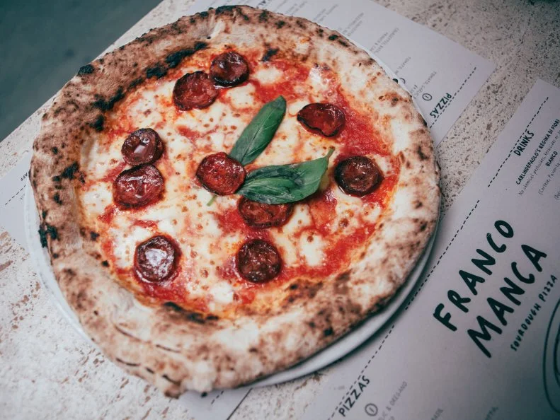 London’s pizza scene got a much-needed reboot in 2008, when Franco Manca opened its first humble outpost amid the heaps of plantain and hair extensions in south London’s Brixton Market. Charcoal-flecked, plate-thin sourdough pizza cooked in a wood-fired oven from Naples — featuring flour from the owner’s Italian hometown — attracted snaking queues and prompted a mini explosion of Franco Ms across the capital. (It also galvanized Brixton Market into becoming the foodie lodestar we know and love today.) The menu hasn’t changed much, still demonstrating a pleasing economy in both length and price. There are six simple pizzas — including a cheese-less tomato number and a tomato-less cheese number — because when ingredients are this good, who needs subterfuge?

Also try: Filishack, Peckham; Silk Road, Camberwell