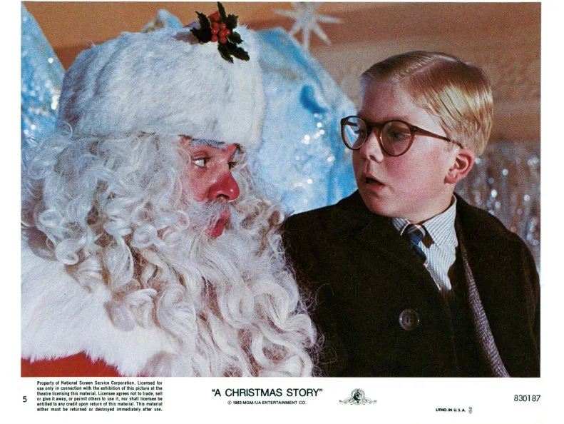 Peter Billingsley sits on Santa's lap in a scene from the film 'A Christmas Story', 1983.