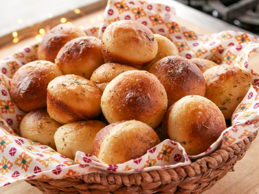Side shot of Herby Buttered Dinner Rolls in whicker basket
