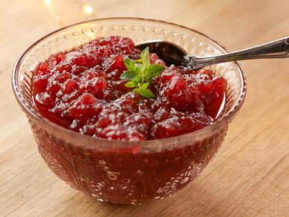 Portrait close up side shot of Spiked Cranberry Sauce in glass dish, with teaspoon for serving