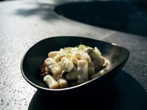 Loaded Baked Potato Gnocchi rest outside in the courtyard at Gram & Dun, as seen on The Grill Dads, Season 1.