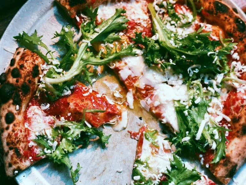 This Bushwick pizzeria evokes the sustainable, crafty ethos of its surrounding neighborhood. The rustic-industrial brick-walled space was formerly an auto garage. The sourdough wood-fired pies are creatively crafted from heirloom wheat and natural yeast, dotted with ingredients sourced from local farms. Pies include the Pops (tomatoes, mozzarella, guanciale, onions and Pecorino), Juno (Robiola, asparagus, greens and Parmesan) and a simple Margherita with house-made mozzarella. Those artistic combinations are paired with market-driven antipasti and salads, seasonal cocktails, natural wines and a somewhat ironic â  Bud and amaroâ   riff on the classic boilermaker.