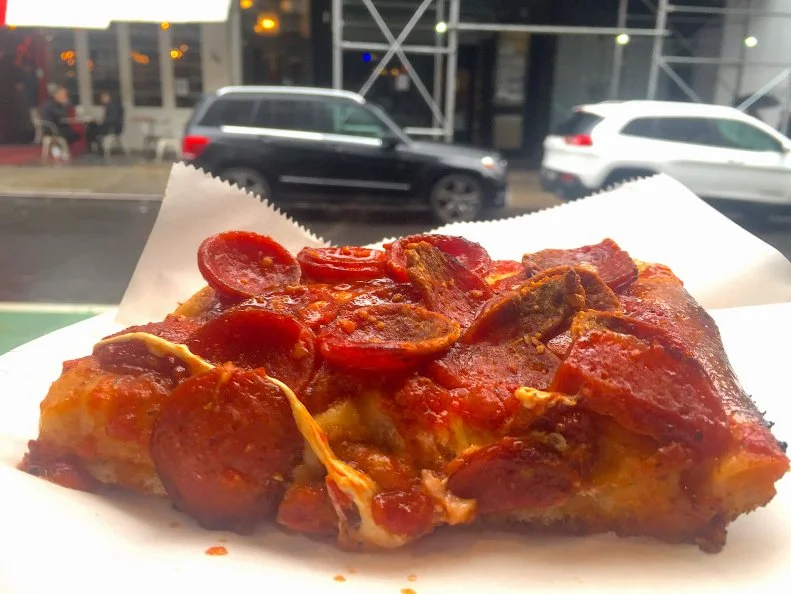 This Nolita take-out joint, ‘Home of SoHo Squares,’ offers four excellent versions of fluffy oversized Sicilian-style pizzas made on a fluffy, crisp base that banishes any fear of a soggy bottom. All are worthy of applause, but the Spicy Spring Pie is the champion. Right atop the olive oil-infused dough, a hearty sprinkling of mozzarella cheese separates the spicy fra diavolo sauce from the foundation, preventing the crust from getting wet and mushy. Spicy pepperoni slices are spread evenly across the whole the block along with a dusting of Romano cheese.
