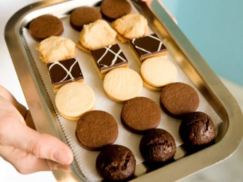 Twelve years ago, wife-and-husband team Dawn Casale and David Crofton opened One Girl Cookies, a tiny bakeshop serving petite cookies with feminine names. Their diminutive treats include the nut-studded Penelope, the fruit-filled Lana and the more cake-like mini whoopie pies that come in flavors like pumpkin spice. The best-seller, however, is the Lucia. Named for Casaleâ  s great-grandmother, it begins with a layered shortbread square topped with espresso caramel and a dark and white chocolate swirl. The process is fairly labor-intensive with large batches of caramel stirred by hand for over an hour.