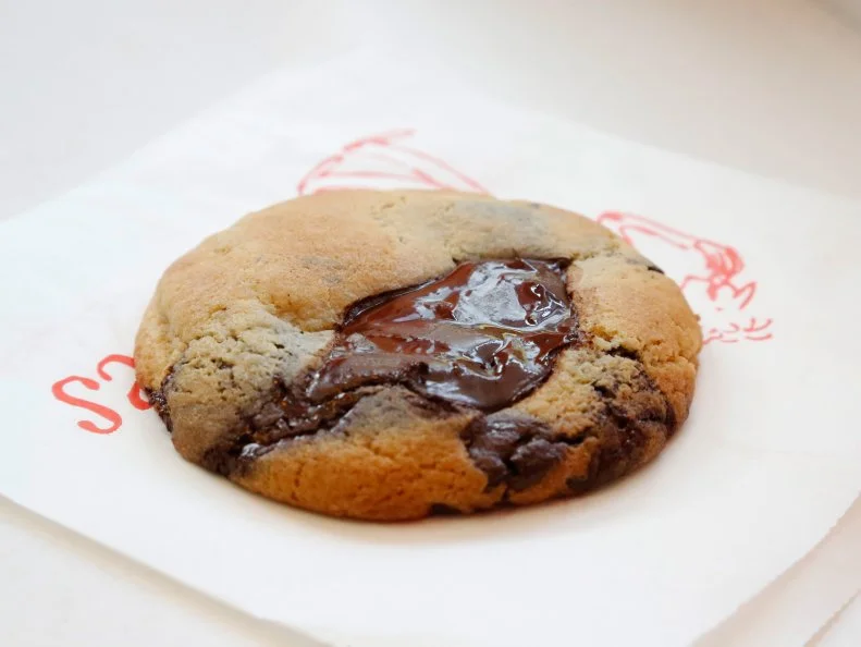 In 1983, cookery writer Helge Rubenstein opened her first cookie shop, sweetly named after her son, in Oxford’s covered market, in England. More than 30 years later, the shop has finally skipped over the pond to open its first U.S. outpost, in New York. The bakery’s nearly three dozen varieties include milk chocolate-peanut butter, dark chocolate with walnuts, triple-chocolate and exclusive flavors made for the American palate, like lemon and snickerdoodle.