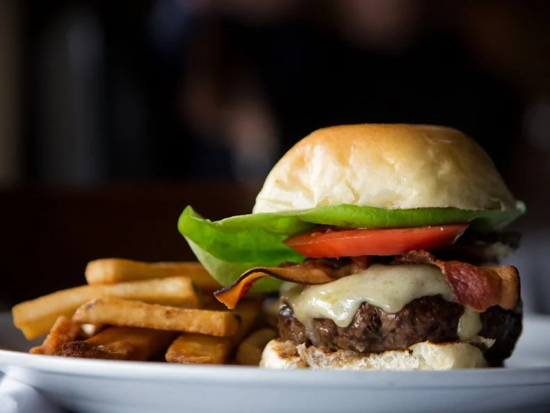 At Jack Fry’s, the sultry Louisville restaurant that first opened in 1933, diners can order Jack’s Burger for lunch or dinner. Jack Fry’s chefs put Black Hawk Farms Black Angus chuck on a brioche bun and then add lettuce, tomato, caramelized onions and spicy-sweet local pickles. The rest of Jack Fry’s menu soars to fine-dining heights, but the burger never disappoints. The City Pool Hall in Monticello serves up another kind of burger, also a favorite for more than 50 years: a hamburger patty flattened and crisped alongside its bun on a venerable flat-top griddle, all crunch and savor. 