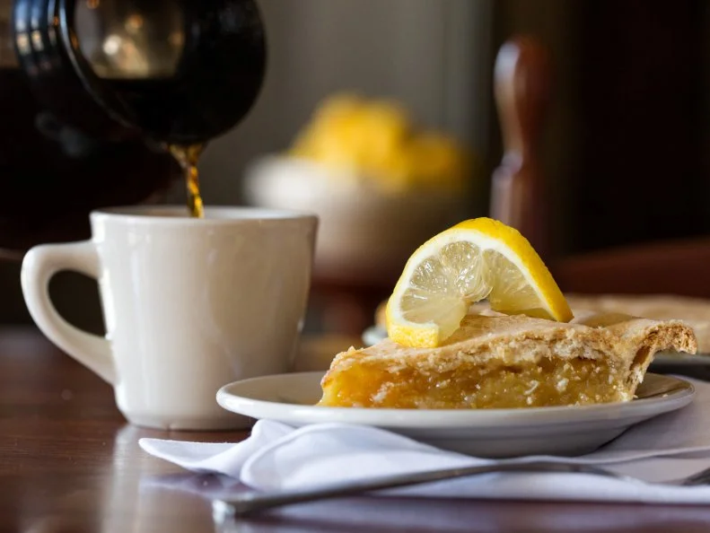 For nearly 50 years, diners have driven to Shaker Village of Pleasant Hill near Harrodsburg for beauty, history, discovery — and the Shaker Lemon Pie. This double-crusted, intensely tart-sweet pie, filled with faintly bitter, paper-thin slices of whole lemon, makes Kentuckians forget all about the lemon meringue and icebox pies in the world outside. Guests from around the country still come in droves for other Shaker foods as well, and for the rich pleasures of enjoying seed-to-table dining in a lovingly restored setting. Big favorites from the menu include tangy tomato-celery soup, the corn muffins or white yeast rolls that are passed with each main meal, and fried chicken.