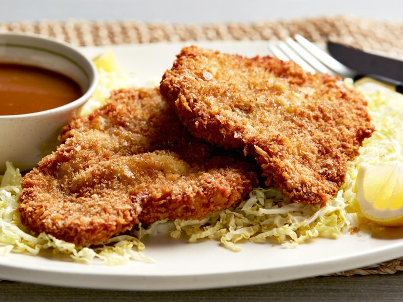 Two pieces of tonkatsu on a bed of shredded cabbage.