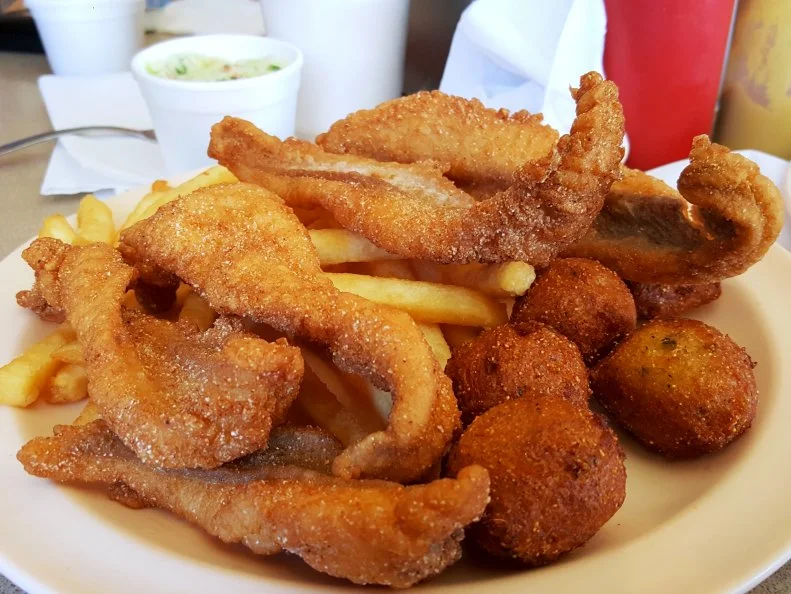 Fried catfish and hushpuppies with fries at The Shack in Jessieville, Arkansas as included in Arkansas's Most Iconic Eats for FoodNetwork.com