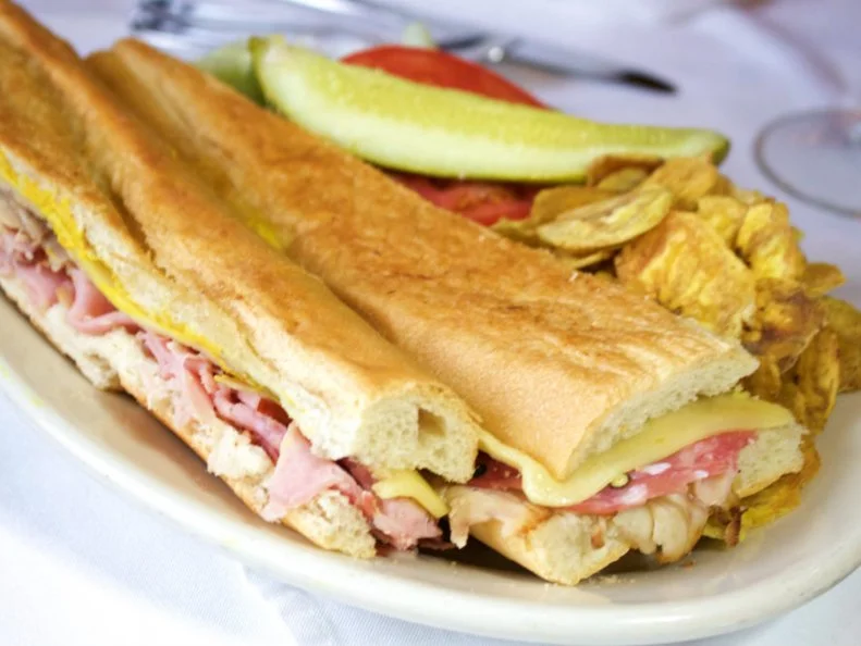 Spanish for "flowers" or something to do with flowers, Florida has a long, deep relationship with the Latin world. Few foods symbolize the manifold history better than the Cuban sandwich, created in 1915 at [Columbia Restaurant](http://www.foodnetwork.com/restaurants/fl/tampa/columbia-restaurant-restaurant), Florida's oldest eatery. Originally called a mixto, the sandwich blends influences from Tampa's heterogeneous population: Genoa salami from Italy, Spanish ham, mojo-marinated pork, Swiss cheese, German pickles and mustard, nestled in fluffy Cuban bread. The latter is still purchased from the 96-year-old La Segunda Central Bakery, which has supplied bread since shortly after the sandwich was invented.