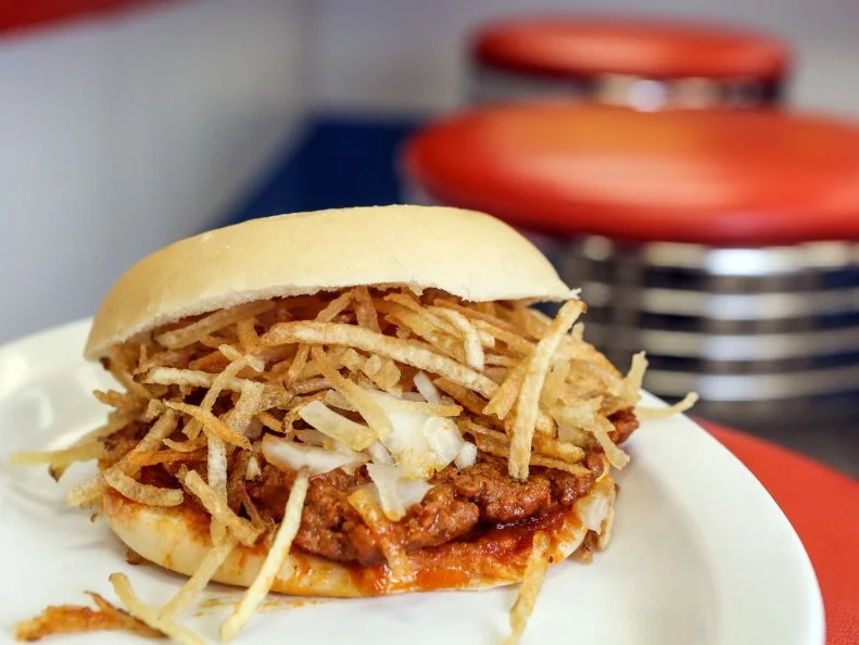 The frita, essentially a Cuban take on a hamburger, has been a Miami staple since the 1950’s, arriving on the shores of South Florida with the mass of immigrants fleeing the Cuban Revolution. The classic variation features a beef patty seasoned with cumin, paprika and pepper, topped with fried potato sticks (papas fritas), sandwiched between slices of flaky Cuban bread. Since 1976, el Rey de las Fritas has served some of the best in town. While the shops — now four, plus a roaming food truck — offer numerous variations (one comes with fried plantains on top), traditionalists stick to the Original Frita Cubana. This one blends ground beef and chorizo into a patty with a “secret formula” of spices, topped with raw onion and julienned fries.