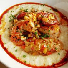 Shrimp and grits may be a low-country dish; however, it's been adopted throughout the crustacean-loving south. In Florida, the seafood staple most often highlights local rock shrimp, a deep-sea variety with a rock-hard outer shell from waters off the Atlantic and Gulf coasts. James Beard Foundation Award-nominated husband-and-wife team James and Julie Petrakis offer their own twist on the dish at their critically acclaimed restaurant, The Ravenous Pig. Sometimes their rendition has Florida rock shrimp, other times, it's locally caught royal red Canaveral shrimp, another deep-sea variety from nearby waters. To craft the dish, the duo sautes shrimp with tomatoes and corn, topped with red pepper flakes and chives, then sets the lot atop Anson Mill grits, highlighted with heavily spiced green-tomato chutney and savory chorizo oil.
