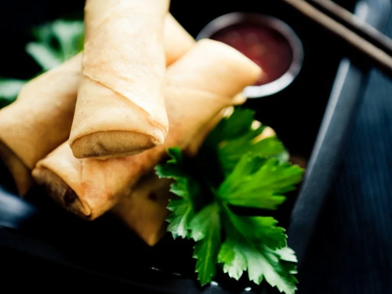 Spring rolls, sauce and chopstick.