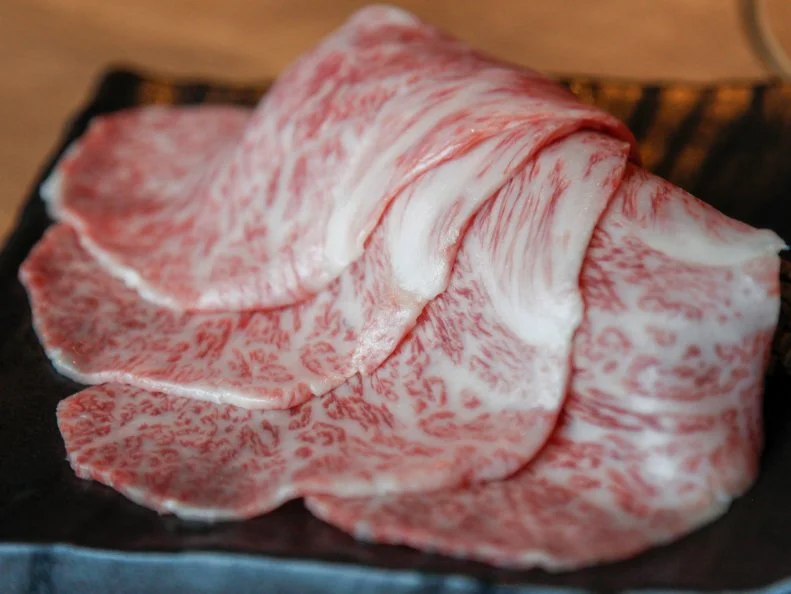 Sumibiyakiniku Nakahara showcases wagyu beef in all its marbled glory. The menu at this upscale yakiniku barbecue restaurant showcases nose-to-tail beef: Choices range from humble offal to super-premium sirloin. Kentaro Nakahara sources his beef directly from small local producers to ensure fresh cuts, which he slices with the precision of a sushi chef. Opt for the tasting menu (from ¥8,500), which includes seven different cuts for diners to grill on the tabletop, or pick a la carte options. The beef tartare is a tower of cubed beef enriched with runny egg yolk. The hire-katsu, a breaded cutlet of lean tenderloin with a rosy center, requires ordering in advance, and it is well worth it.