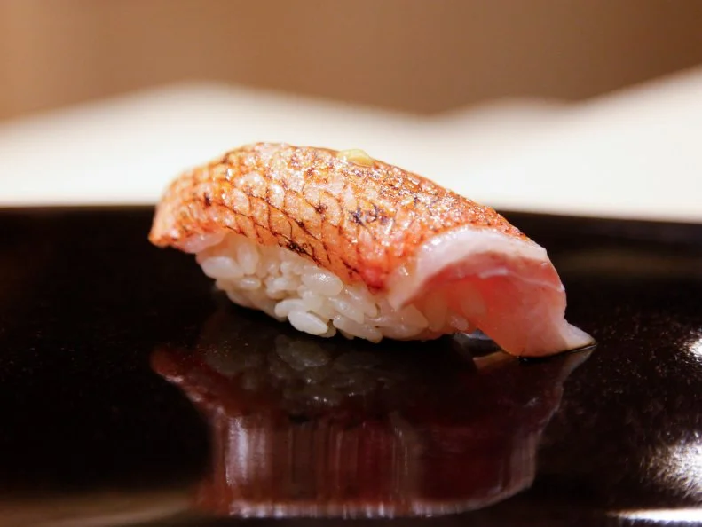 There is no street sign in front of this high-end sushi restaurant, but regulars know exactly where to go. Takaaki Sugita gained a cult following as the master of Miyako Sushi before opening Sugita last year in the Nihonbashi district. The chef excels at the art of aging and applies an arsenal of subtle techniques to maximize the flavor of each ingredient. Deep garnet slices of bonito, matured for four days, have a buttery texture and exquisite depth. A short cure in salted water unlocks the intense sweetness of raw white prawns, and a marinade of miso infuses salmon roe with sweet-and-savory complexity. One of Sugita’s specialties is ankimo (monkfish liver pâté), slowly simmered over low heat in soy sauce, sake and mirin. Served with a thimbleful of sake, it is a palate-expanding experience of umami, the fifth taste.