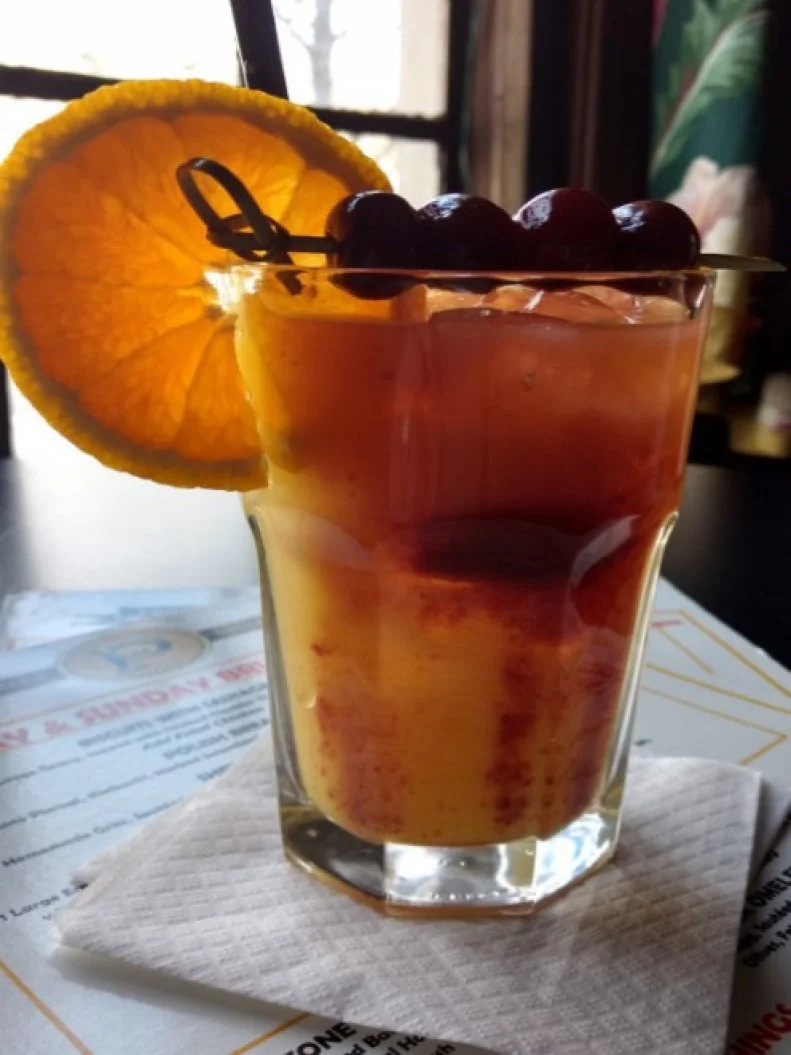 When Bonnie Flinner of Prosperity Social Club was laid up on a cold, snowy Cleveland day after ankle surgery, her husband, Clint, whipped up a tasty pick-me-up drink using the ingredients they had on hand. After she returned to worked, Bonnie adapted the recipe for the brunch menu, calling it an Orange Whipp as a nod from two music enthusiasts to Blues Brother John Candy, who ordered three Orange Whips while listening to a band perform. This version shakes bourbon with amaretto, which is strained over ice and topped with orange juice and a cherry-brandy cordial float.